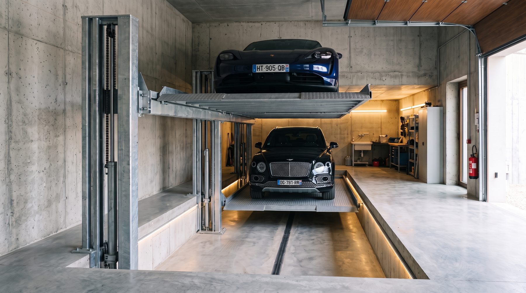 Doubleur de parking dans un garage béton, deux véhicules de gabarits différents superposés, plateau bas descendu en fosse